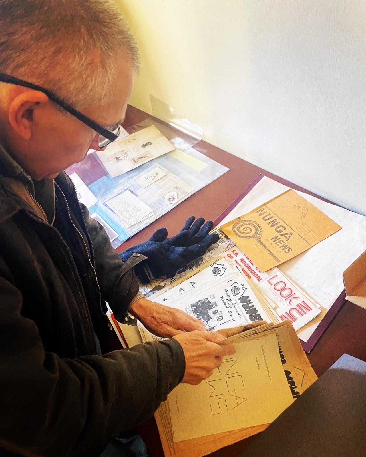 Andrew Wilson looking through the display featuring Nunga News. 