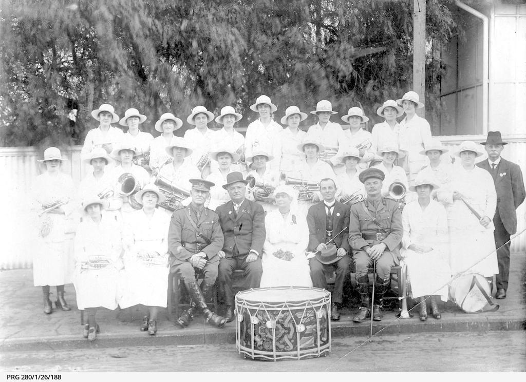 Women members of the Burra Ladies Brass Band sitting and standing with two army officers and two men in civilian dress on 'Violet Day' in South Australia. SLSA PRG 280/1/26/188