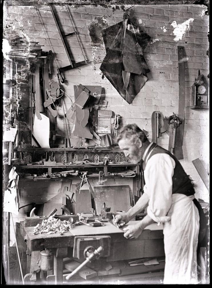 Brooker employeed measures wood in carpentry workdshop-c1911