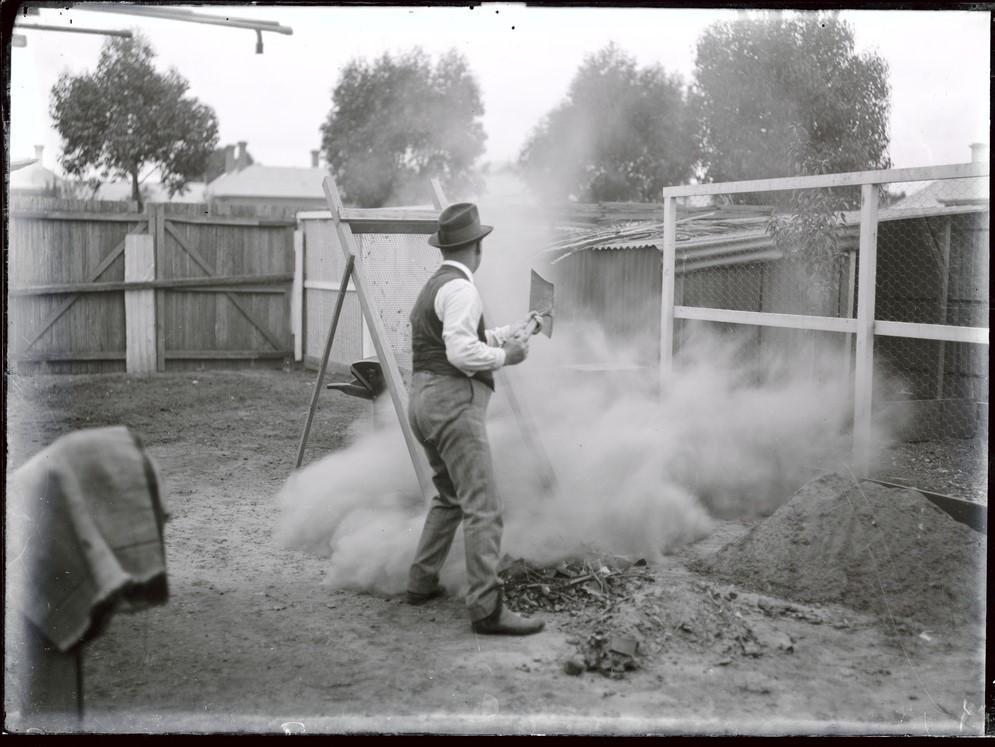 Man shovelling dirt in backyard