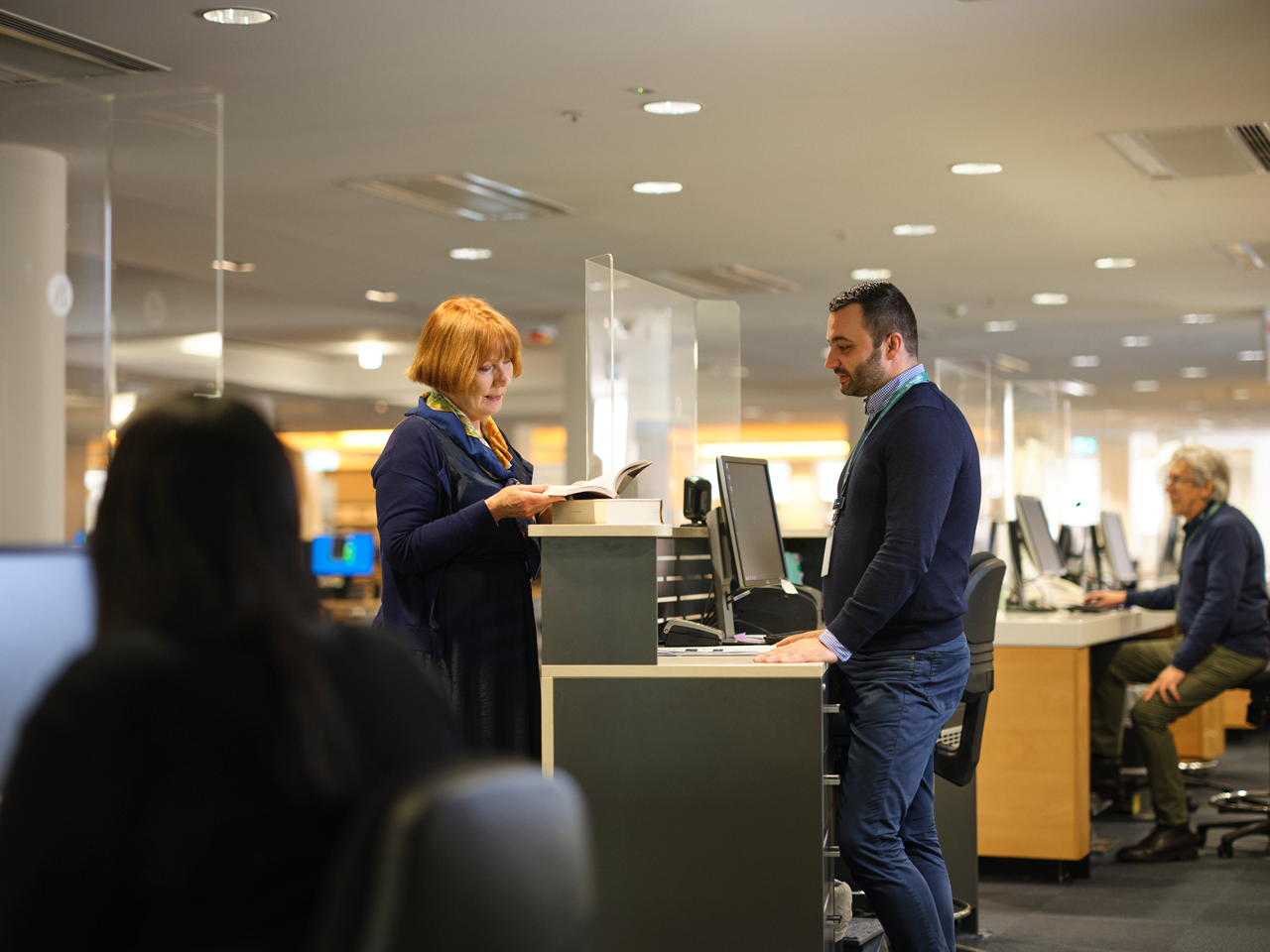 Librarian helping a customer with their research query.