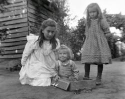 Three Brooker chldren in garden, May, Frank centre sitting in cardboard box,  Dorothy on right