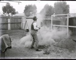 Man shovelling dirt in backyard