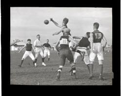 Football match, man leaping for football, possibly at oval in Unley