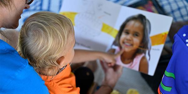 Indigenous child having a book read to them